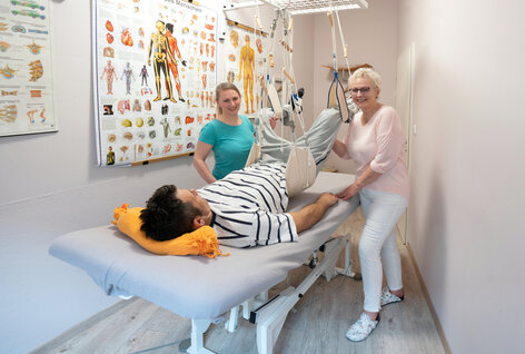 Fachkraft und Auszubildende mit Reha-Patient